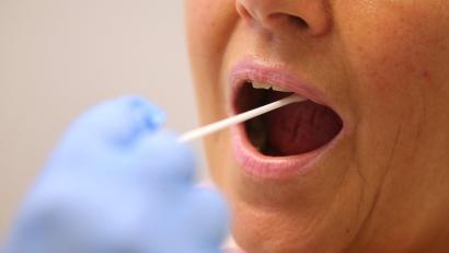 Symbolbild: Karl-Josef Hildenbrand/dpa
Ein Arzt nimmt in einer Hausarztpraxis mit einem Tupfer einen Abstrich bei einer Frau für einen Coronatest.