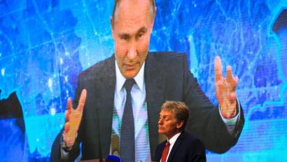 Bild: Alexander Zemlianichenko/AP/dpa
Wladimir Putin spricht bei  einer Pressekonferenz per Video zu Medienvertretern, Kremlsprecher Dmitri Peskow hört zu.