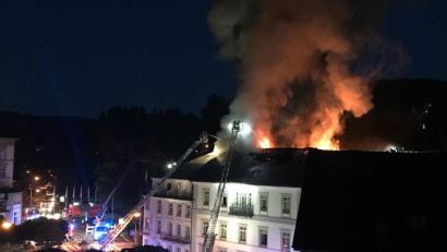 Bild: Patrick Neumann/SWR/dpa
Die Feuerwehr löscht von Drehleitern aus das Hotel „Badischer Hof“ (2021). Etwa 160 Gäste mussten vor dem Feuer in Sicherheit gebracht werden.