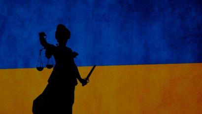 Bild: Sebastian Gollnow/dpa
Friedensdemonstration in Frankfurt - und Justitia auf dem Gerechtigkeitsbrunnen zeichnet sich vor einer Ukraine-Flagge ab.