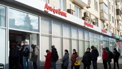 Bild: Victor Berzkin/AP/dpa
Menschen in Moskau stehen vor einem Geldautomaten der Alfa Bank Schlange.