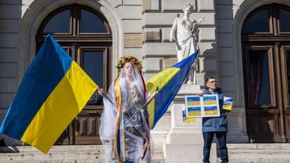 Bild: Martial Trezzini/KEYSTONE/dpa
Mit einem Kleid aus Gasmasken demonstriert eine Frau in Genf gegen den Einmarsch Russlands in die Ukraine.