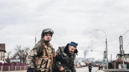 Bild: Diego Herrera/EUROPA PRESS/dpa
Ein ukrainischer Soldat hilft einem älteren Mann, die Straße zu überqueren.