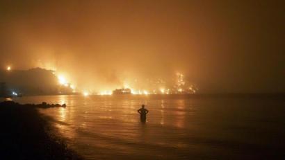 Bild: Thodoris Nikolaou/AP/dpa
Ein Mann beobachtet, wie sich Waldbrände dem Strand von Kochyli in der Nähe des Dorfes Limni auf der Insel Evia (Griechenland) nähern.