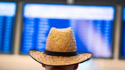 Bild: Jonas Walzberg/dpa
Ein Urlauber schaut auf die Abflugtafel in Hamburg.