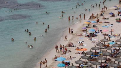 Bild: Clara Margais/dpa
Touristen genießen an einem Strand bei Puerto Portals auf Mallorca die Sonne und das Meer.