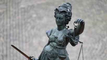Bild: Arne Dedert/dpa/Symbolbild
Eine Statue der Justitia hält eine Waage und ein Schwert in der Hand.