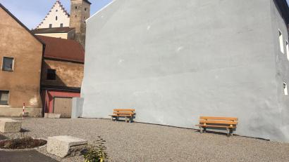 Bild: ihl
Die grau geschotterte, triste Fläche am Mühlweg 2 wird aufgepeppt. Neben einer E-Bike-Ladestation und Radständer könnte dort eine Litfaßsäule stehen und mobile Pflanzkübel sowie Liegemöbel zum Verweilen einladen.