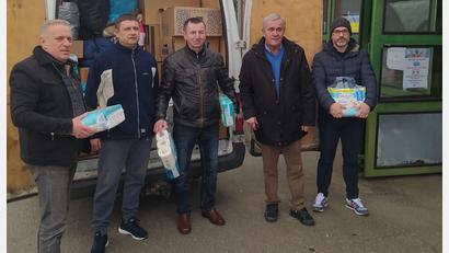 Bild: exb/Neue Zeiten
Arkadiy Voloshyn (links), der ukrainische Fahrer Sergej Iwanow (Zweiter v. links) und Waldemar Hock (Mitte) stehen vor dem vollgepackten Bus, der Spenden in die Ukraine bringt.