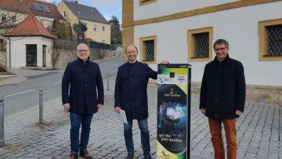 Bild: Sabrina Elefant/exb
Die Elektroautos der Caritas-Sozialstation sollen künftig an der Ladestation der Gemeinde "tanken", vereinbarten Diakon Richard Sellmeyer, Bürgermeister Hans Ram und Stephan Prechtl von INAS (von links).