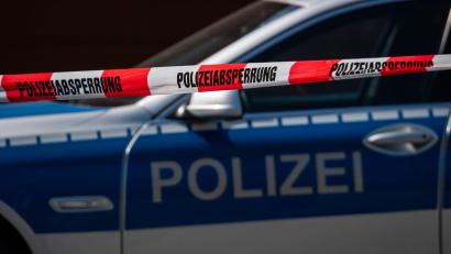 Bild: Robert Michael/dpa-Zentralbild/dpa/Symbolbild
Ein Polizeiauto steht hinter einem Absperrband der Polizei.