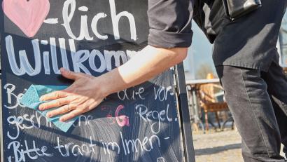 Bild: Georg Wendt/dpa
Kellner Tonet Devolli vom Restaurant Mühlstein in Wedel beseitigt die Hinweise zu den 3G-Regeln.