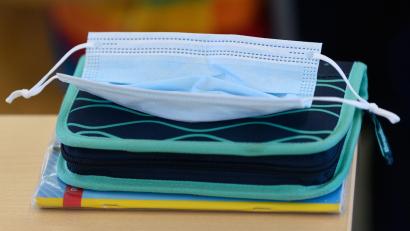 Bild: Robert Michael/dpa-Zentralbild/dpa/Symbolbild
Eine OP-Maske liegt in einem Klassenzimmer auf einem Federmäppchen.