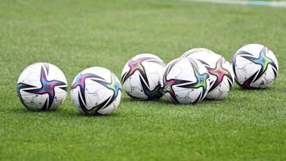 Symbolbild: Swen Pförtner/dpa
Bälle liegen auf einem Fußballplatz.