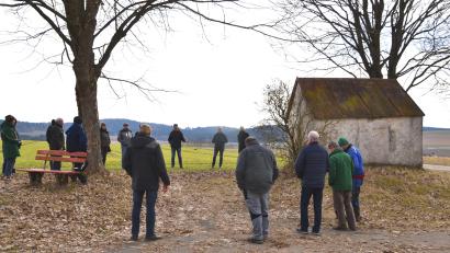 Bild: gi
Etwa 20 Bürger aus dem Gemeindeteil Tröbes nahmen an der Info-Veranstaltung an der „Wongerkapelle“ teil. Der örtliche Gemeinderat Bernhard Rom (Dritter von rechts, hinten) hatte dazu eingeladen. Auch Bürgermeister Armin Bulenda (hinten, rechts) will dazu beitragen, den Bestand der Kapelle zu sichern.