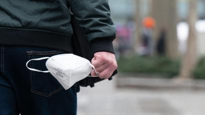 Symbolbild: Sebastian Kahnert/dpa
Ein Mann hält eine FFP2-Maske in der Hand.