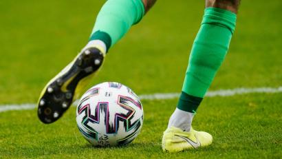 Symbolbild: Uwe Anspach/dpa
Ein Fußballspieler spielt den Ball.