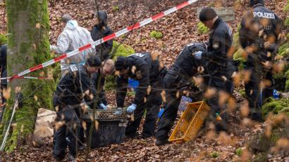 Bild: Peter Kneffel/dpa/Archivbild
Poizisten suchen ein Gebiet im Wald ab, an dem zuvor menschliche Knochen gefunden worden sind.