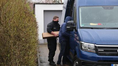 Bild: Vifogra/dpa
Ermittler der Polizei verladen nach einer Durchsuchung einen Karton in ein Fahrzeug.