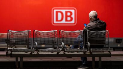 Bild: Peter Kneffel/dpa/Symbolbild
Ein Mann wartet auf einer Bank in einem Hauptbahnhof.