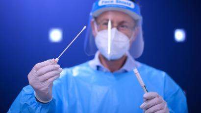 Symbolbild: picture alliance/Robert Michael/dpa-Zentralbild/dpa
Ein Arzt hält in der Teststation einen Coronavirus-Test in den Händen. Am Freitag, 8. April, gingen die Inzidenzen vier Tage in Folge zurück.