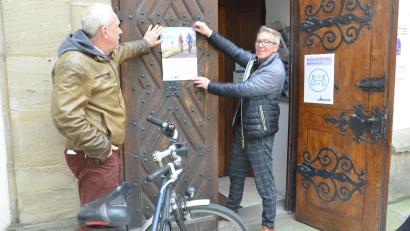 Bild: Kunz
Fördervereinsvorsitzender Hans-Peter Pauckstadt-Künkler (links) und Bürgermeister und Routenkoordinator Reinhold Wildenauer bringen an der Pforte der Michaelskirche die Einladung zum Simultankirchenfest an.