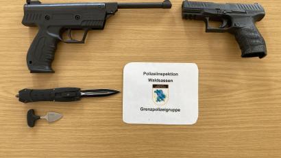 Bild: Polizeiinspektion Waldsassen/exb
Neben einer geringen Menge der Droge Crystal Meth, stellten die Beamten auch eine Druckluftpistole, eine zugriffsbereite Schreckschusspistole sowie zwei verbotene Messer (Springmesser und Faustmesser) sicher.