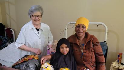 Bild: Projekt Feuerkinder/exb
Glücklich ist die kleine Patientin Amina nach ihrer Behandlung, hier im Bild mit ihrer Großmutter und Dr. Annemarie Schraml.