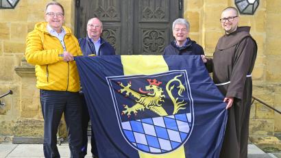 Bild: Susanne Schwab, Stadt Amberg/exb
Bürgermeister Martin Preuß (links) überreicht Michael Koller, Franz Mertel und Pater Seraphin Broniowski (weiter von links) die neue Fahne der Stadt Amberg.