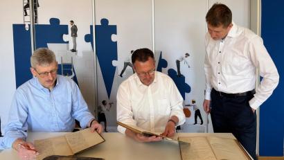 Bild: njn
Vorstandssprecher Joachim Geyer (Mitte) blättert mit seinen Vorstandskollegen Robert Haubner (links) und Thomas Keck (rechts) in alten Protokollbüchern.