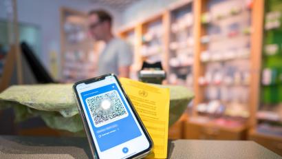 Symbolbild: Oliver Dietze
Ein Smartphone mit dem QR-Code eines digitalen Impfausweises liegt zusammen mit einem Impfbuch auf dem Tisch einer Apotheke.
