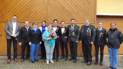 Bild: Eules/exb
Jubilarin Brigitte Neudecker zeigt das Bild im Kreise der Gratulanten