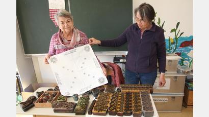 Bild: kro
Adele Rustler und Wilma Siller (von links) mit einem Stoffdruck und den Models, die vor ihnen liegen.