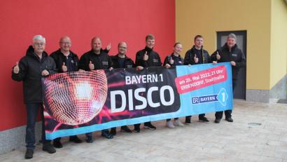 Bild: fks
Daumen hoch: Vorsitzender Albert Vollath (links) und Kommandant Bernhard Schmidt (rechts) kündigen mit weiteren Feuerwehrleuten die Bayern-1-Disco in Erbendorf an.
