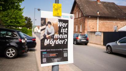 Bild: Nicolas Armer/dpa
Ein Plakat mit der Aufschrift „Wer ist mein Mörder?“ hängt in der Innenstadt von Wörth.