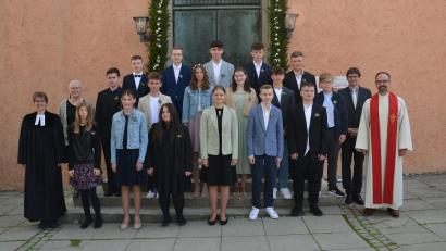 Bild: dob
17 Jugendliche feiern am Muttertag Konfirmation. Anhand eines Schokoriegels erklären Pfarrerin Carmen Riebl (links) und Diakon Fabian Endruweit (rechts) als Dialogprediger dabei die Liebe Gottes. Warmer Sonnenschein begleitet die Familien an diesem erinnerungswürdigen Tag.