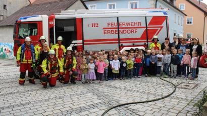 Bild: njn
Für die Buben und Mädchen des Kunterbunt-Kindergartens gab es während des Einsatzes viel zu sehen. Mit auf dem Bild die Feuerwehrmänner mit Kommandant Bernhard Schmidt (Zweiter von links) sowie die Erzieherinnen mit Leiterin Sabine Schreiber-Schöpf (Dritte von links).