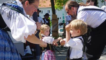 Bild: fppp
Beim offenen Tanzen und Singen am Egerland-Brunnen zeigten schon die dreijährigen Zwillinge Ella und Falk ihre Freude an der Bewegung zur Egerländer Musik. Die passende Anleitung bekommen sie von ihrem Papa Christof und ihrer Mama Mona, die Vorsitzende der Landesführung Hessen ist.