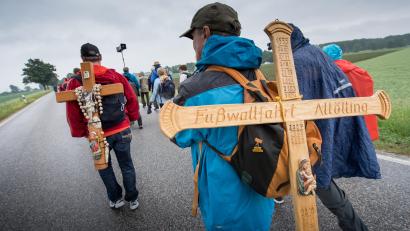 Bild: Peter Kneffel / dpa
Pilger tragen während der Fußwallfahrt von Regensburg nach Altötting ein Holzkreuz auf dem Rücken.
