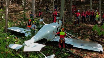 Bild: Fotokerschi.At / Kerschbaummayr/APA/dpa
Feuerwehrleute sind neben einem der abgestürzten Flugzeuge im Einsatz.