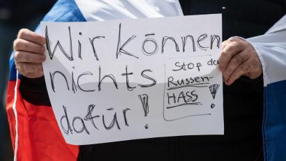 Bild: Boris Roessler/dpa
„Wir können nichts dafür - Stop den Russen-Hass“ steht auf dem Schild eines Mannes, der an einer prorussischen Kundgebung teilnimmt.