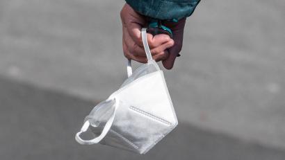 Bild: Boris Roessler/dpa/Symbolbild
Ein Passant trägt eine FFP2-Maske in der Hand.