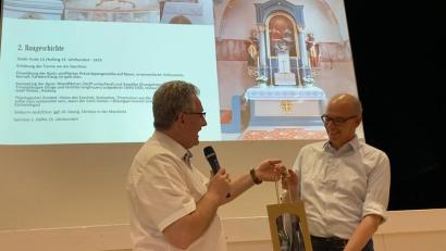 Bild: aub
Mit zwei Flaschen Domwein bedankte sich Pfarrer Hannes Lorenz bei Wolfgang Neiser für dessen ebenso spannenden wie vielfältigen Festvortrag "Perschen - Meilensteine einer 900-jährigen Geschichte".