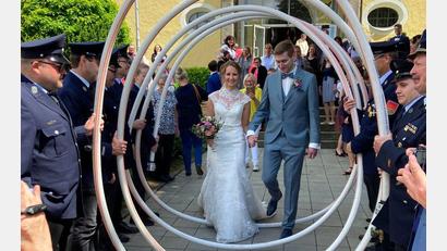 Bild: le
Sandra Neubeck-Weiser und Felix Weiser durchschreiten ein Schlauchspalier der Feuerwehr Plößberg.