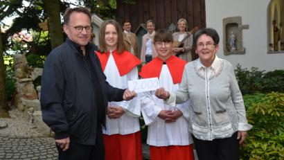 Bild: dob
Christa Wildenauer (rechts) zeigt ein großes Herz für die Ministranten in der Pfarrgemeinde. Anlässlich der Maiandacht in der Christophorus-Kapelle mit der Gruppe "TriAngel" aus Waldthurn (im Hintergrund) überreicht sie mit zwei ihrer Enkelkinder an Dekan Alexander Hösl 2000 Euro.