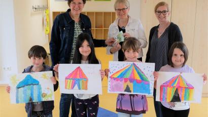 Bild: do
Frauenbundvorsitzende Elisabeth Nickl (li) und Vorstandsmitglied Melanie Reis (re) bei der Spendenübergabe an Rektorin Gabi Bodner. Einige Grundschulkinder freuen sich bereits auf die Zirkuswoche und zeigen ihre "Kunstwerke"