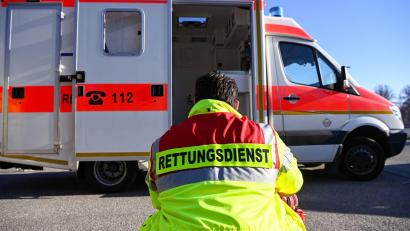 Bild: Jens Kalaene/dpa/Symbolbild
„Rettungsdienst“ steht auf der Jacke eines Mannes vor einem Rettungswagen der Feuerwehr.