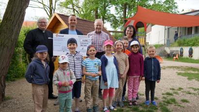 Bild: Alois Schröpf/exb
Pfarrer Gottfried Schubach (links) freut sich mit den Kindern vom Kindergarten St. Johannes über die großzügige Spende.