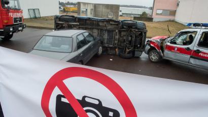 Symbolbild: Klaus-Dietmar Gabbert/dpa
Feuerwehrleute haben auf einem Übungsgelände einen Sichtschutz aufgestellt, der deutlich zeigt, dass das "Fotografieren verboten" ist. Auch die Behinderung von Einsatzkräften ist strafbar.