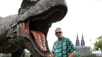 Bild: Thomas Banneyer/dpa
Jeff Goldblum vor einer T-Rex Figur in Köln. Der Schauspieler ist auf Werbetour für den neuen „Jurassic-World“-Film.